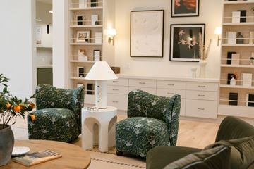 Glendale apartment for rent - A living room with a green patterned chair and a white table with a lamp on it.