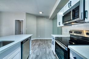 Scottsdale apartment for rent - a kitchen with white cabinets and a black stove top oven
