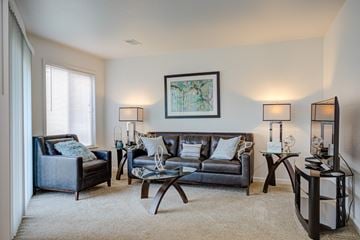 Westland apartment for rent - A living room with a grey couch, a black chair, a coffee table, and a painting on the wall.