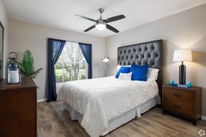 Orlando apartment for rent - A bedroom with a white bed and a ceiling fan.