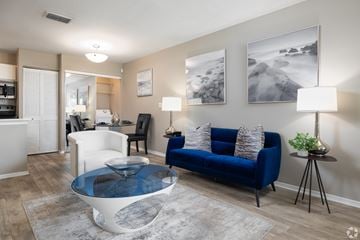 Orlando apartment for rent - A living room with a blue couch and a glass coffee table.
