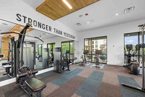 Asheville apartment for rent - A gym with a variety of equipment and a sign that says "STRONGER THAN YESTERDAY".