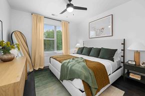 Asheville apartment for rent - A bedroom with a bed, nightstand, and a ceiling fan.