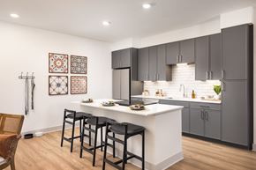 Aurora apartment for rent - A kitchen with a white counter and black bar stools.