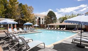 Glendale apartment for rent - A pool surrounded by lounge chairs and umbrellas.