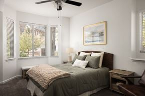 Glendale apartment for rent - A bedroom with a bed, a ceiling fan, and a window with blinds.
