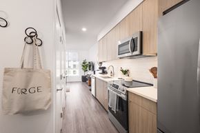 Denver apartment for rent - a kitchen with wooden cabinets and a tote bag on the wall