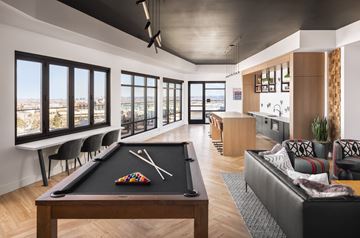 Lakewood apartment for rent - A billiard table is in the middle of a living room with a view of the city.