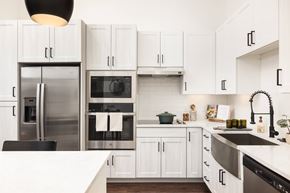 Denver apartment for rent - A modern kitchen with white cabinets and stainless steel appliances.