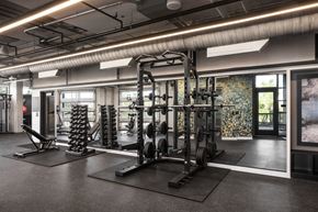 Denver apartment for rent - A gym with a variety of equipment including a squat rack, bench press, and a rowing machine.