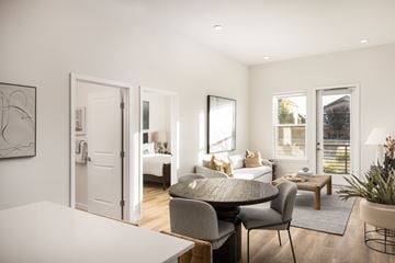 Aurora apartment for rent - A modern living room with a grey sofa and a white table.