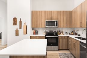 Aurora apartment for rent - A kitchen with wooden cabinets and a white island.