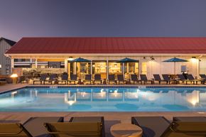 Aurora apartment for rent - A pool with chairs around it and a building in the background.