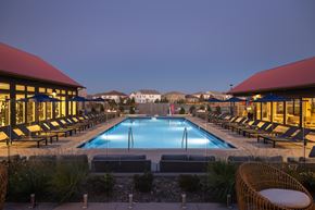 Aurora apartment for rent - A large outdoor swimming pool surrounded by lounge chairs and plants.
