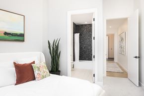 Denver apartment for rent - A bedroom with a white bed and a painting on the wall.