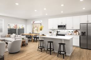 Aurora townhouse for rent - A modern kitchen with white cabinets and a large island.