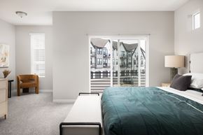 Aurora apartment for rent - A bedroom with a large bed and a view of a building outside the window.