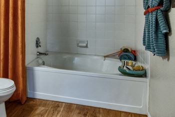 A white bath tub in a bathroom next to a toilet