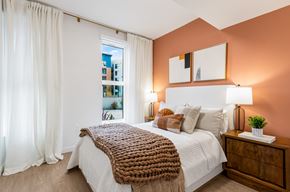Mountain View apartment for rent - A bedroom with a large bed and a window with white curtains.