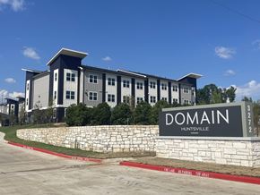Huntsville apartment for rent - A building with the sign "DOMAIN" in front of it.