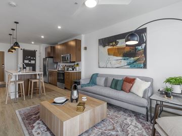 West Jordan apartment for rent - A modern living room with a grey couch and a wooden coffee table.