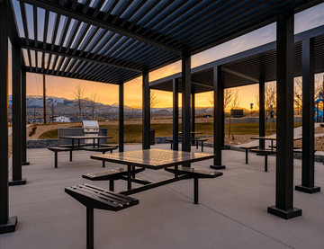 Bluffdale townhouse for rent - A patio with tables and benches is set up under a roof.