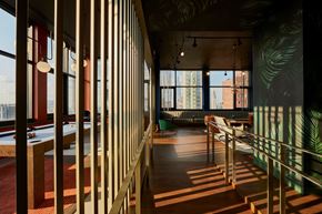 New York apartment for rent - A long hallway with a pool table and a green plant on the wall.