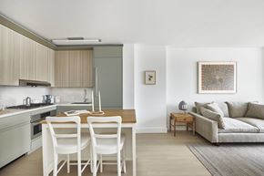 New York apartment for rent - A modern kitchen with white chairs and a dining table.