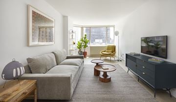 New York apartment for rent - A living room with a grey couch, a yellow chair, a wooden coffee table, and a grey cabinet.