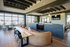 Covington apartment for rent - A modern office space with a long wooden table and chairs.