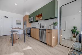 Salt Lake City apartment for rent - A kitchen with wooden cabinets and a white brick backsplash.