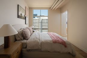Seattle apartment for rent - A bedroom with a large bed and a window with blinds.