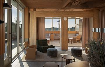 Seattle apartment for rent - A modern living room with wooden furniture and large windows overlooking a body of water.