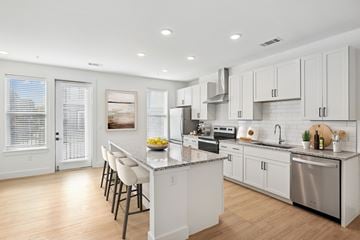 Richmond apartment for rent - A modern kitchen with white cabinets and stainless steel appliances.