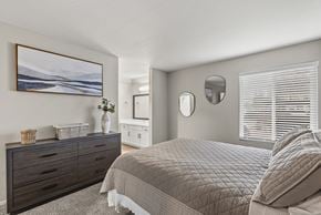 Sacramento apartment for rent - A bedroom with a large bed and a painting on the wall.