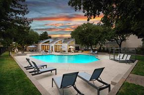 Sacramento apartment for rent - a swimming pool with chaise lounge chairs and a house in the background