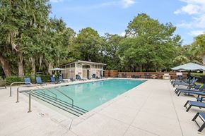 Mt. Pleasant apartment for rent - A pool surrounded by trees and chairs.