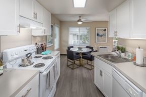 Tigard apartment for rent - Kitchen with white appliances and a dining room with a table and chairs at Summerfield, OR, 97224