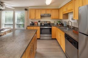 Beaverton apartment for rent - a kitchen with wooden cabinets and stainless steel appliances