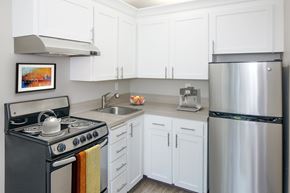 Lake Oswego apartment for rent - A kitchen with white cabinets and a stainless steel refrigerator.