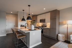 Minneapolis apartment for rent - A modern kitchen with a white island and wooden chairs.