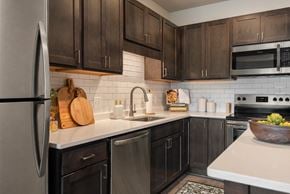 West Saint Paul apartment for rent - A kitchen with black cabinets and a white countertop.
