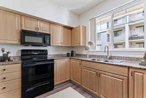 Boise apartment for rent - A kitchen with wooden cabinets and black appliances.