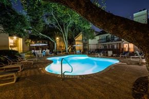 San Antonio apartment for rent - a pool at night with a tree in the foreground