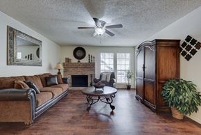 San Antonio apartment for rent - a living room with a fireplace and a ceiling fan
