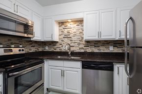 Altamonte Springs apartment for rent - A kitchen with white cabinets and a black dishwasher.