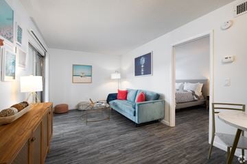Altamonte Springs apartment for rent - A living room with a blue couch and a wooden cabinet.