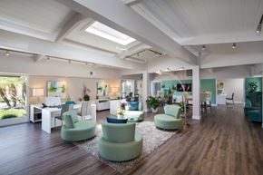 San Jose apartment for rent - A spacious room with green chairs and wooden floors.