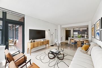 Arlington apartment for rent - A modern living room with a white couch and a wooden entertainment center.