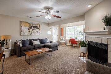 Memphis apartment for rent - A living room with a grey couch, a coffee table, a fireplace, and a painting of a horse on the wall.